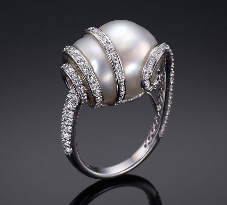 Diamonds swirl delicately around an exquisite Baroque Pearl.