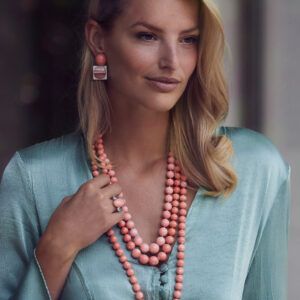Model wearing Assael Angel Skin Coral Necklace and ring